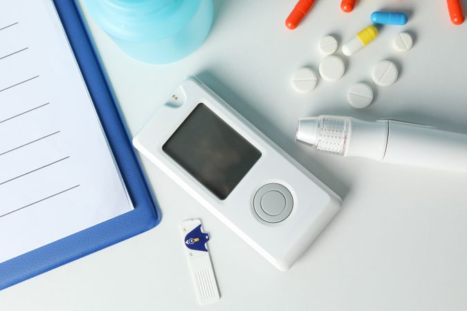 Diabetes accessories on light background, top view