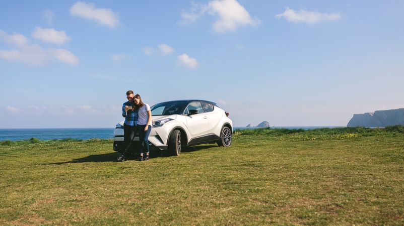 Couple with car looking mobile