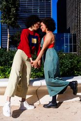 Female couple holding hands and facing each other in city park