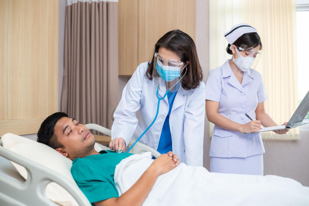 Woman doctor using stethoscope examine to sick man with nurse