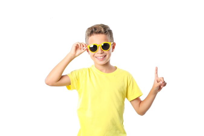 Boy in yellow t-shirt with sunglasses isolated on blank background
