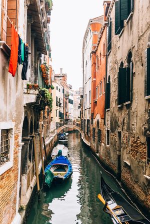 Gondola on water canal between concrete buildings in Venice, Italy 