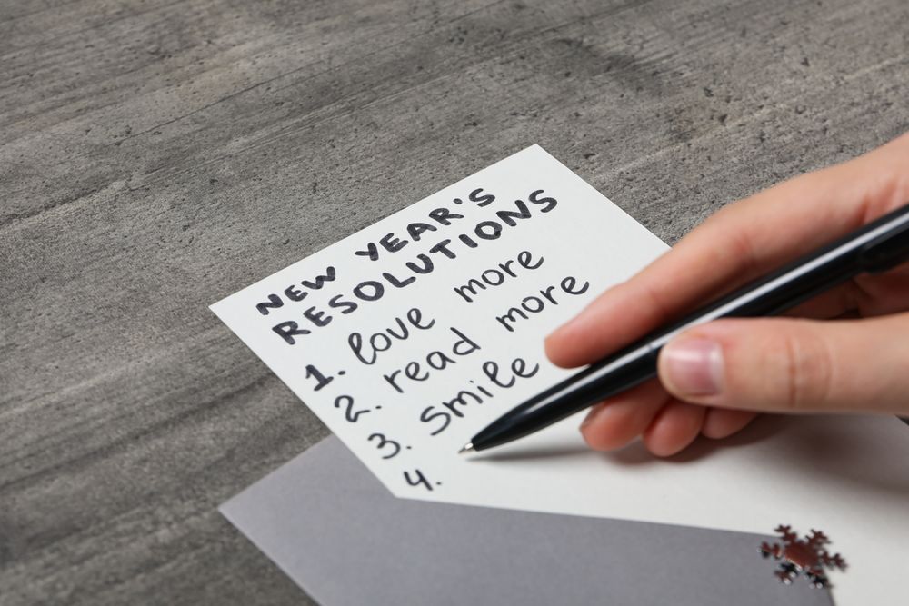Envelope, paper with list and pen in hand on gray background, close up