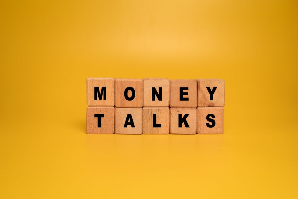 money talks words on wooden blocks isolated on orange background
