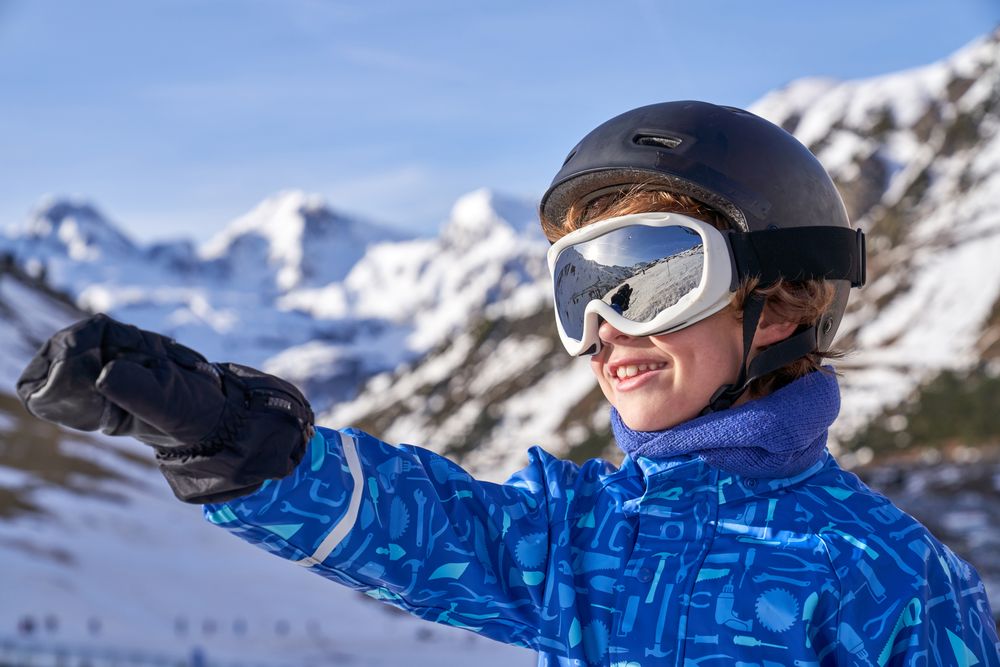 Boy pointing away on ski resort