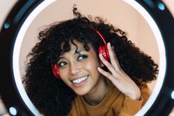 Smiling Black woman listening to music in headphones
