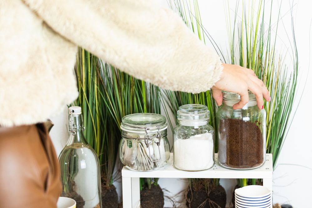 Unrecognizable person hand picking up a glass jar full of coffee