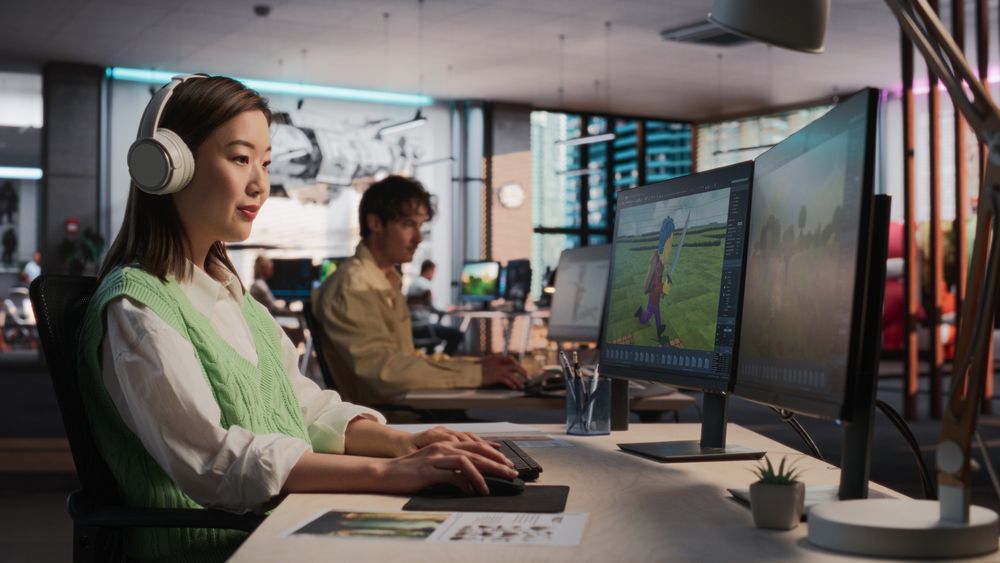 Female Asian Game Designer Using Desktop Computer, Designing Unique World And Characters In 3D modelling Software For RPG Video Game.