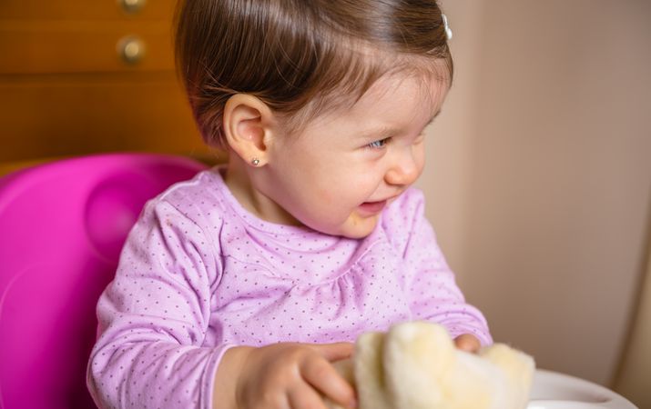 Happy baby laughing and playing with a toy sitting