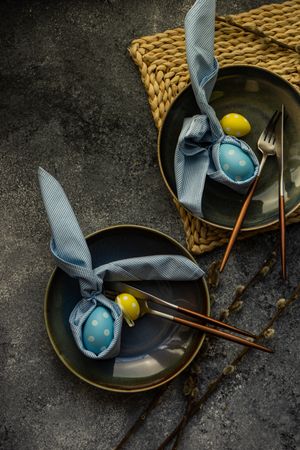 Top view of Easter holiday table setting with decorative blue and yellow eggs on grey counter