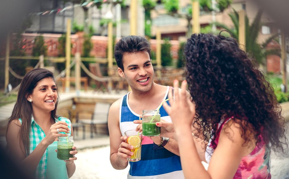 Laughing friends having cocktails in garden