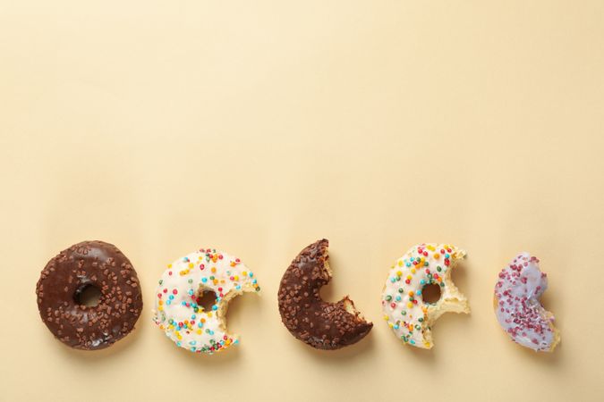 Tasty donuts on beige background, space for text