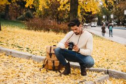 Trendy male with backpack and camera