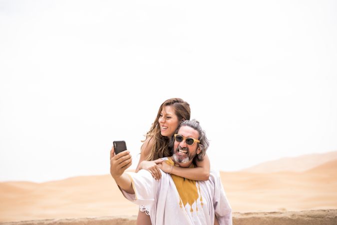 Laughing couple taking selfie on exotic terrace
