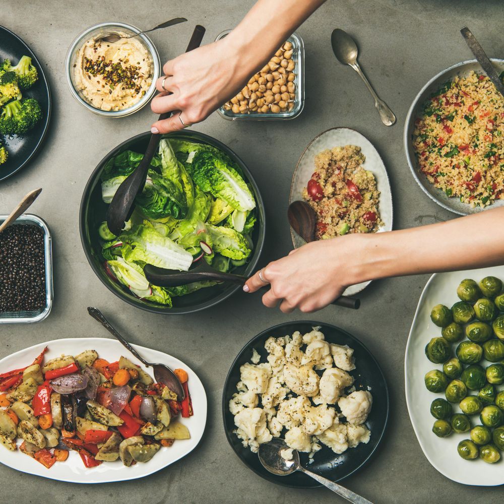 Vegan dinner table setting of healthy dishes in plates on table