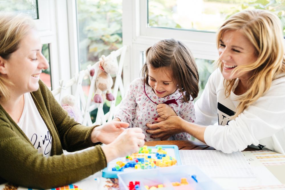 Woman playing board game with daughter and granddaughter