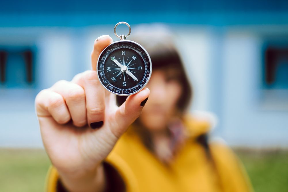 anonymous woman with compass near eye