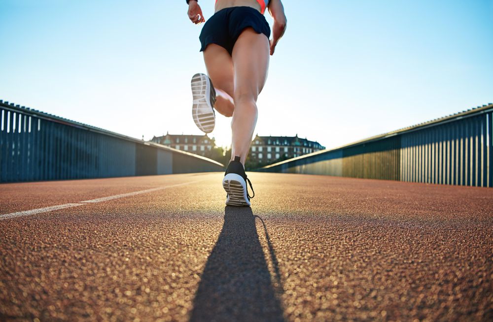 Shot of a female’s muscular legs running across a bridge