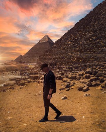 Man standing beside pyramids during sunset in Giza, Egypt 