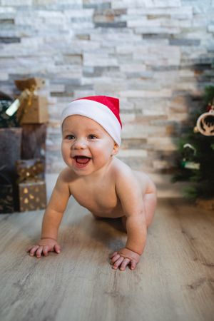 Happy baby lying near Christmas tree