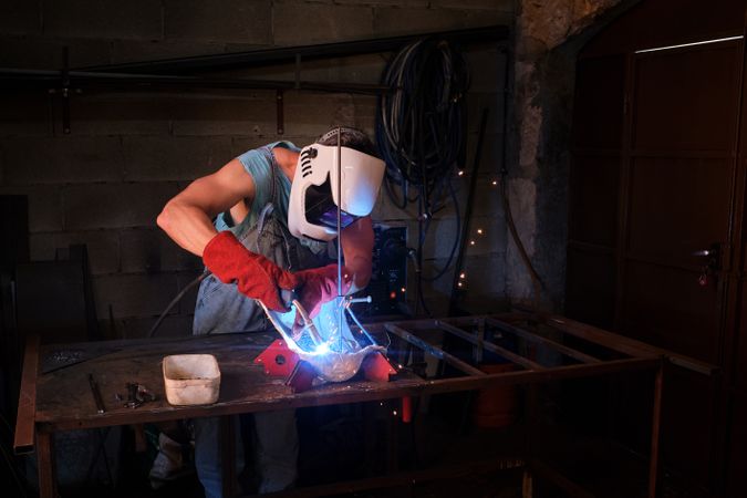 Craftsman in process of welding in garage