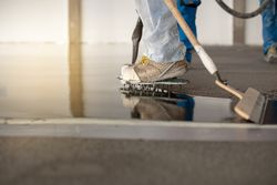 Worker working on the floor of an industrial building with special shoes to avoid damaging the floor.