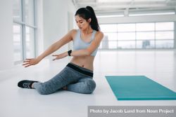 Woman practicing yoga moves before the workout session at fitness studio 0Joed5