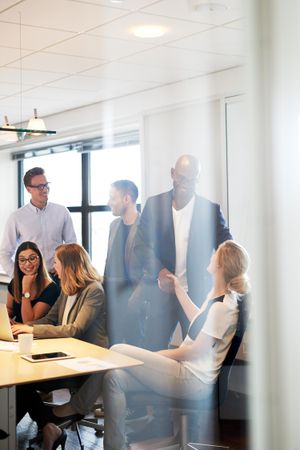 Business women and men chatting at the end of a meeting, vertical