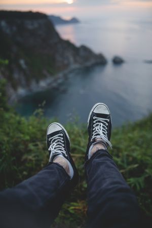 Person legs on seascape background during sunset