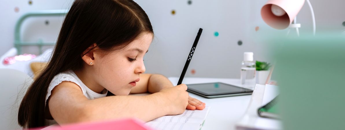 Girl doing homework sitting at a desk