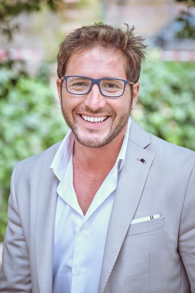 Smiling young man in modern clothes and eyeglasses