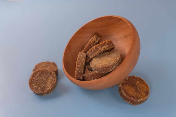 Traditional palm sugar blocks placed in a wooden bowl