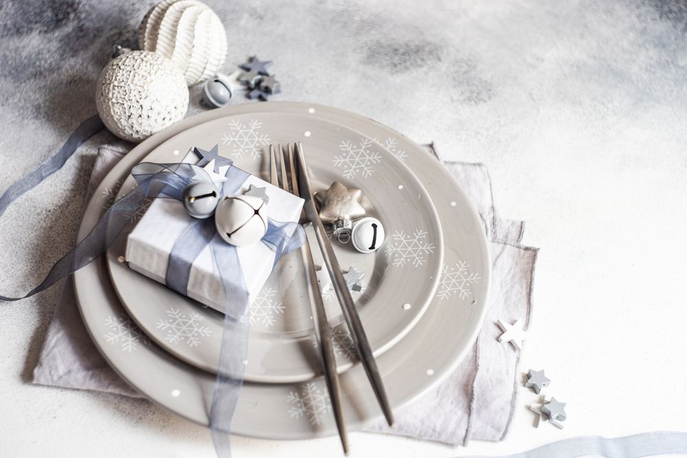 Wrapped Christmas present with ornaments on table setting