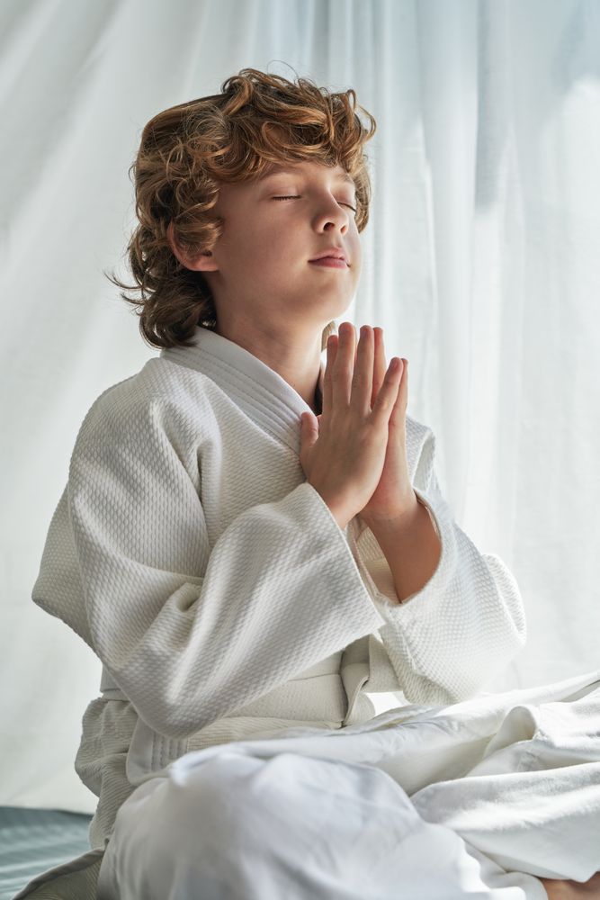 Dreamy boy meditating in Lotus pose