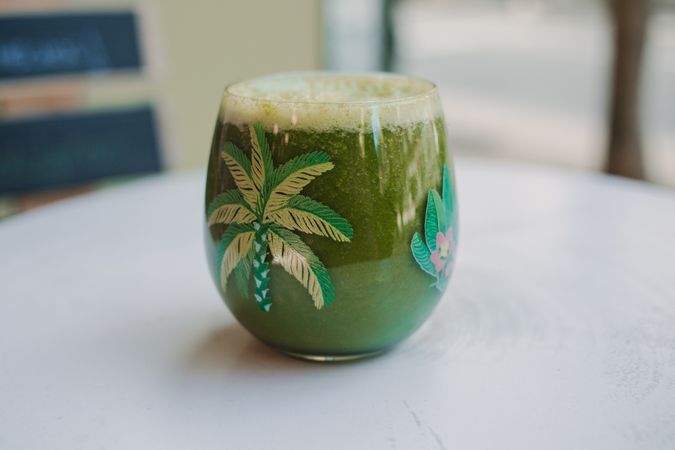 Delicious green smoothie with frothy in glass