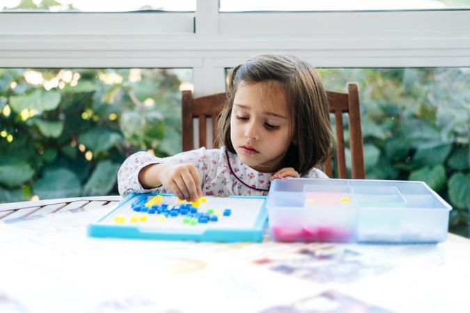 Girl playing with mosaic board game