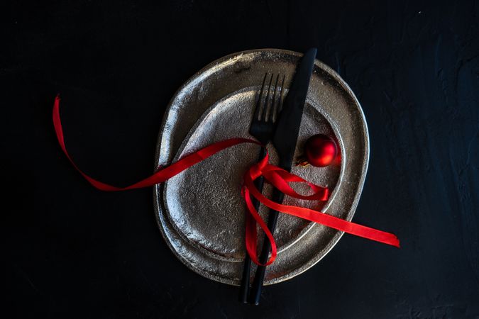 Minimal Christmas table setting with ceramic plate and red decor