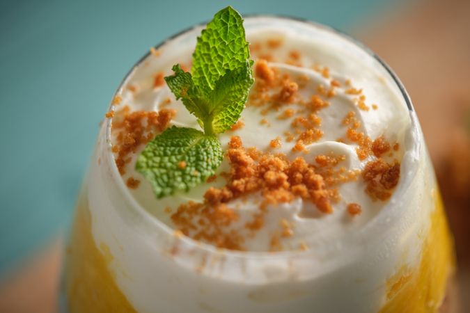 Cheesecake with mint in glass on table