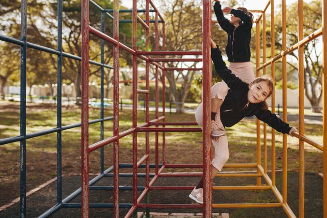 Small girls playing on metal structure at the park