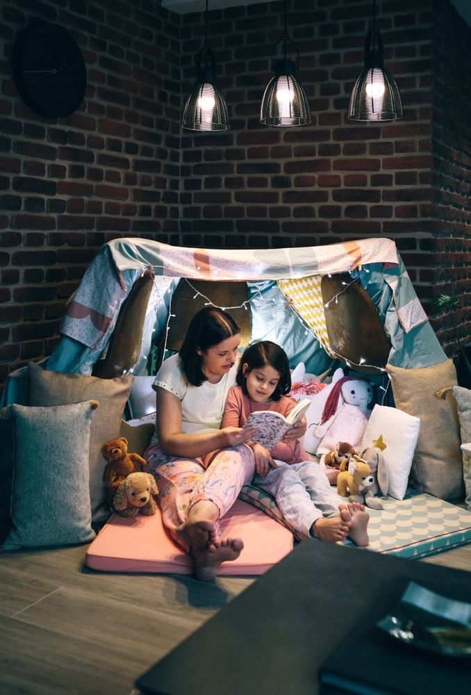 Mother and daughter having a pajama party reading a book