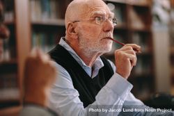Older man sitting in classroom listening to a lecture with concentration 5qqGq5