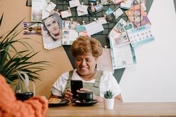 Older Black woman with smart phone at cafe