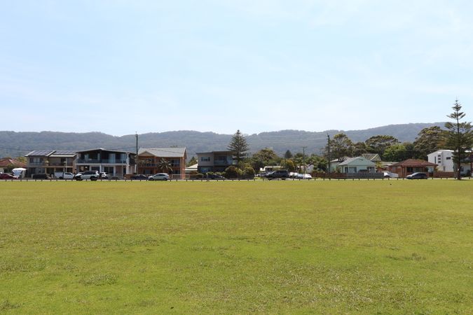 Houses With Mountain View And Large Green Lawn In A Residential Area On A Sunny Day