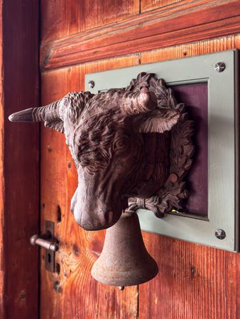 Cow bell knocker on chalet door in Rossiniere, VD