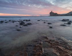 Sundown sky over sea and stony coast