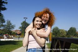 Red haired woman hugging her friend from behind 5nexM0