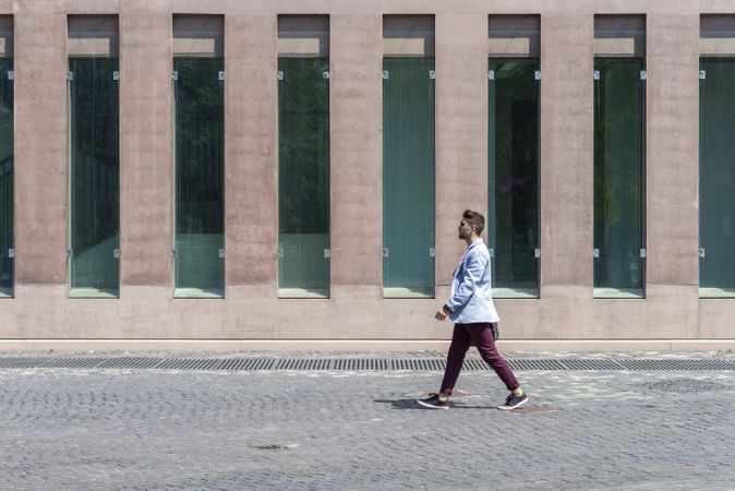 Young trendy professional walking in street wearing smart casual jacket