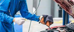Banner of gloved hand of repairman checking oil of car engine