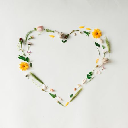 Heart shape made of yellow flowers and leaves