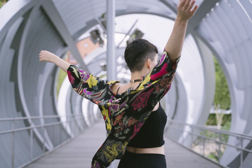 Woman in colorful shirt stretching arms high